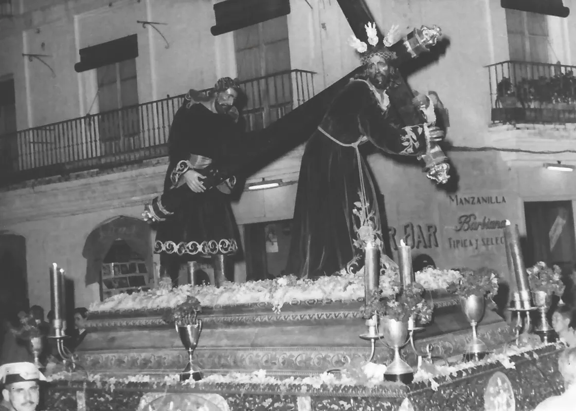 El Consuelo de Sanlúcar, a su paso por la calle Ancha en 1959, procesionando con el Cirineo adquirido a la Esperanza de Triana y que la cofradía sanluqueña sigue conservando. Foto extraída de la web oficial de la Hermandad del Consuelo.