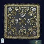 Pañuelo bordado en hojilla de oro, entremezclando hojilla lisa con rizadas, así como con hojilla de plata, sobre tul. El diseño destaca la flor de la Jara como ornamento principal, dispuesta en los puntos claves de la pieza (Jesús Castizo Ramírez, 2025). Foto extraída de las redes sociales de la Hermandad de la Tercera Caída.